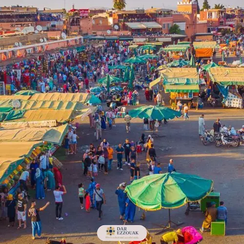 Aerial view of Jemaa el‑Fnaa square at sunset with crowds and food smoke